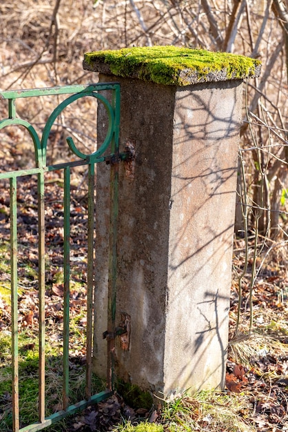 Foto columnas de hormigón de musgo y cercas de hierro forjado corrosionadas viejos adornos de metal