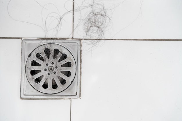 Coluna de perda de cabelo no banheiro após a lavagem queda de cabelo problema grave diário em fundo brancoSoluções para a perda de cabelo
