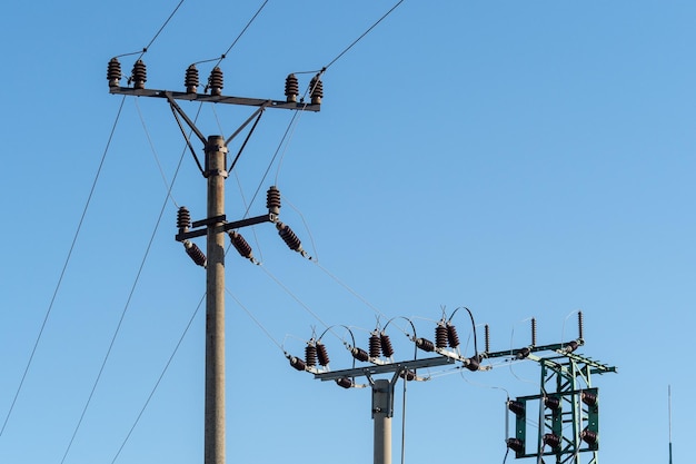 Coluna elétrica e fios de alta tensão no fundo do céu azul