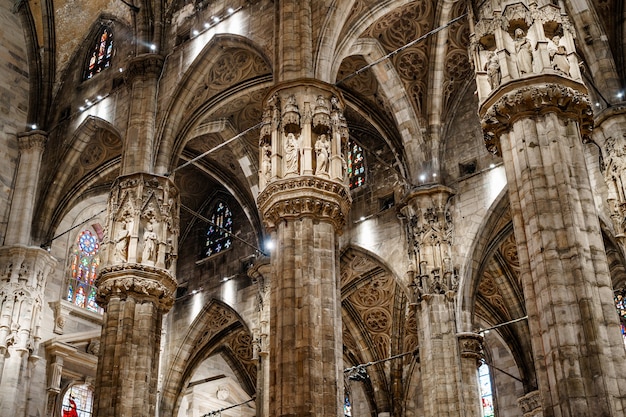 Colunas altas esculpidas com estátuas no duomo itália de Milão