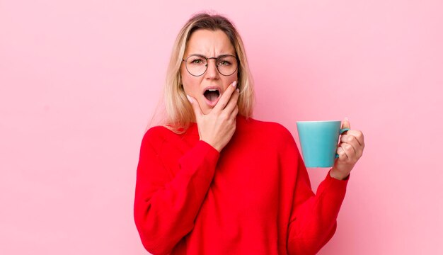 com a boca e os olhos bem abertos e mão no queixo