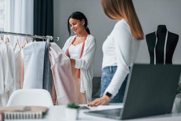 Com a cliente Costureira está em seu escritório que está com roupas diferentes