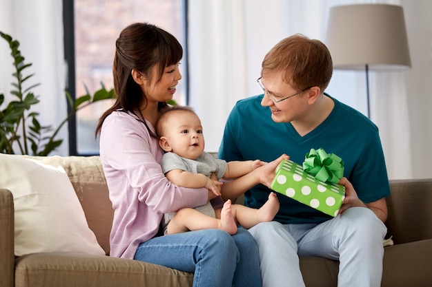 com a mãe e o bebé a dar um presente de aniversário ao pai