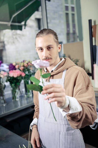 Com amor. Florista satisfeita com um sorriso no rosto enquanto olha para a câmera