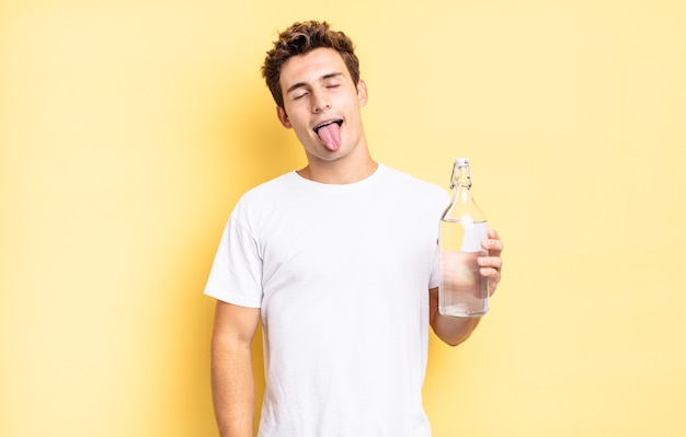 Foto com atitude alegre, despreocupada, rebelde, brincando e mostrando a língua, se divertindo. conceito de garrafa de água