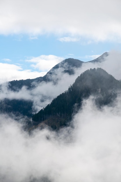 Com nuvens envolvendo montanhas nos Alpes Áustria