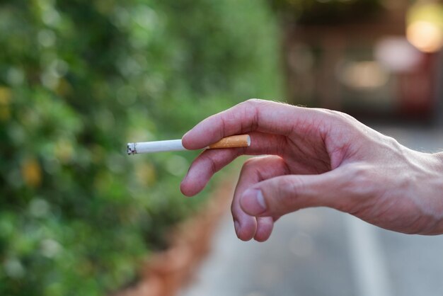Foto com o cigarro na mão.