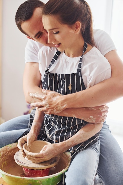 Com o namorado ou marido Jovem ceramista tem um trabalho dentro de casa com produto de barro artesanal Concepção de cerâmica