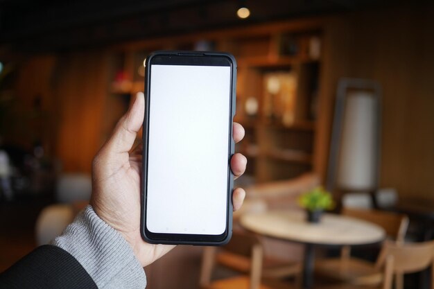 Com o smartphone na mão em um café moderno com a tela vazia
