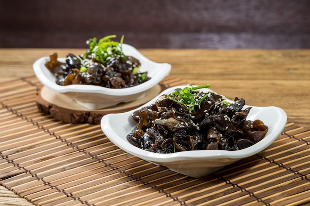 Com palitos cCold Black Fungus servidos em prato isolado na vista superior do tapete em mesa de madeira Comida de Hong Kong