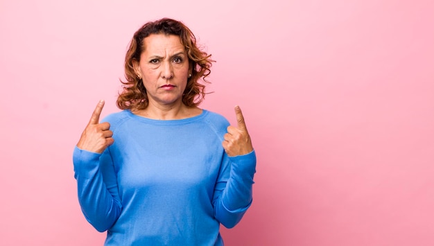 Com uma atitude ruim parecendo orgulhoso e agressivo apontando para cima ou fazendo sinal divertido com as mãos