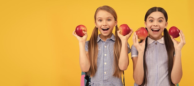 Coma frutas para ser fofo Amigos de escola felizes seguram maçãs Alimentação saudável Sempre coma direito Retrato de menina criança com pôster horizontal de maçã Cabeçalho de banner com espaço de cópia