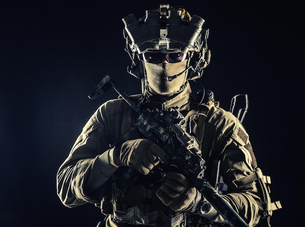 Combatente de comando de elite empresa militar privada mercenário de operações especiais militar de segurança ou atirador de serviço secreto equipado com armas modernas e estúdio de munição em fundo preto