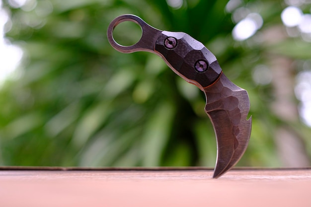 Combatiente táctico de cuchillo Karambit sobre fondo verde