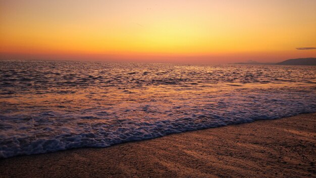 Combinação de pôr do sol e praia. pôr do sol laranja colorido na praia