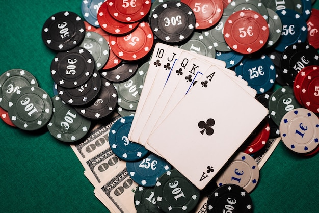 Combinação vencedora de cartas no poker do casino. royal flush, um monte de fichas e dinheiro dólares