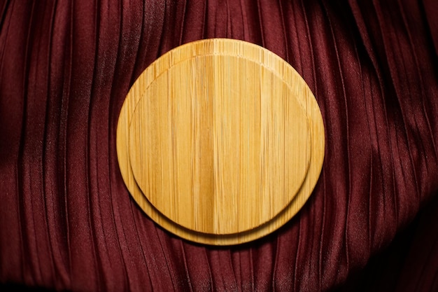 combinación de madera redonda sobre un fondo texturizado de tela roja