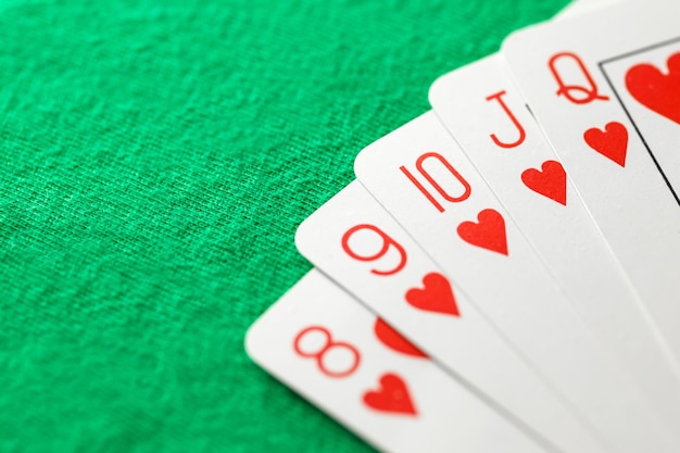 Combinaciones de cartas de póquer de color rojo de corazón de ocho a reina en fondo verde enfoque selectivo