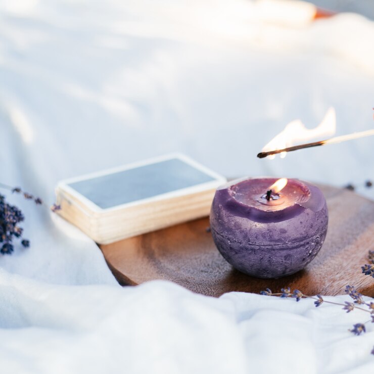 Combine as velas das luzes com ao lado do baralho de cartas e flores de lavanda, na superfície branca e de madeira