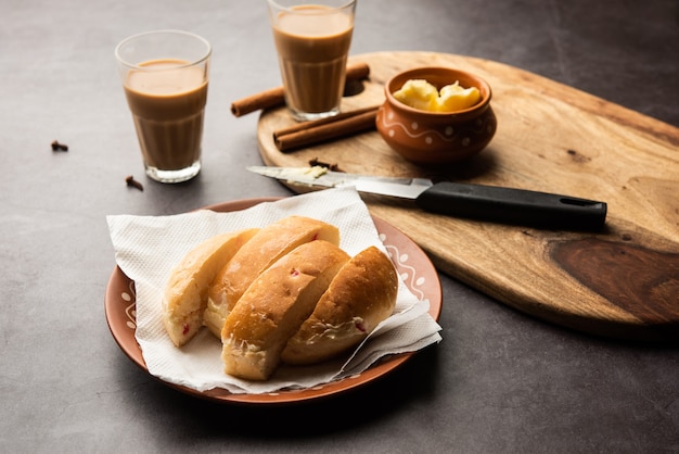 El combo Bun-maska Tea o bun Maska chai presenta un panecillo ligeramente dulce salpicado de pasas que se corta por la mitad y se carga con mantequilla saludable, comida de Mumbai