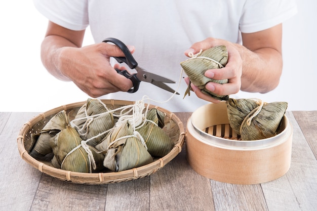 Come zongzi (bola de masa de arroz) en Dragon Boat Festival, comida tradicional asiática