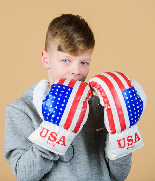 Comece a carreira de boxe Garoto esportista usa luvas de boxe com a bandeira dos eua Conceito de boxe americano Criança atleta praticando habilidades de boxe Esporte de boxe Rumo à vitória Confiante em sua força