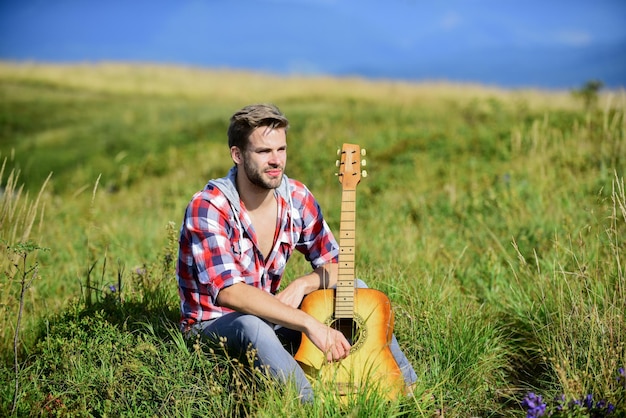 Comece a música homem sexy com guitarra em camisa quadriculada cowboy homem com guitarrista acústico música country música hipster moda feliz e livre ocidental camping e caminhadas