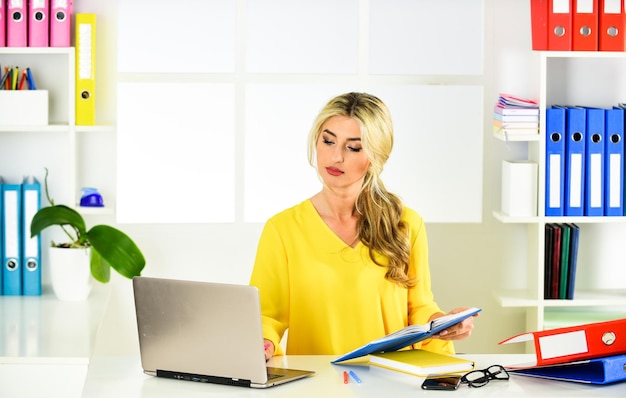 Comece um ótimo gerente de coisas no trabalho empresária confiante senhora chefe loira sexy na mesa professora de aparência inteligente no escritório mulher com cabelos cacheados trabalhando no laptop secretária de óculos