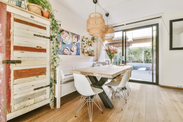 Un comedor con una mesa de madera y sillas blancas.