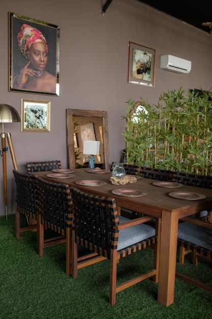 Un comedor con una pared de bambú y una mesa de madera con sillas y un bambú