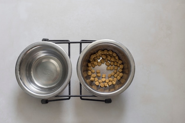 Foto comedouro para animais comida para gatos duas tigelas com comida para gatos e suporte para água no chão, vista de cima