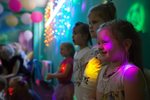 Comemorando o aniversário das criançasCrianças em uma festa em raios coloridos