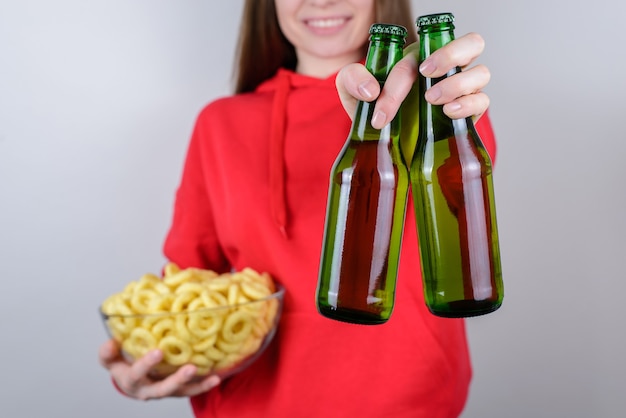 Comemore o conceito de amigos da festa. Foto recortada de perto retrato de alegre feliz legal otimista excitada senhora segurando duas garrafas em mãos isoladas de fundo cinza