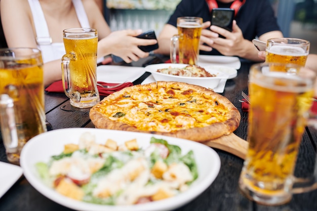 Comendo pizza e bebendo cerveja em um café