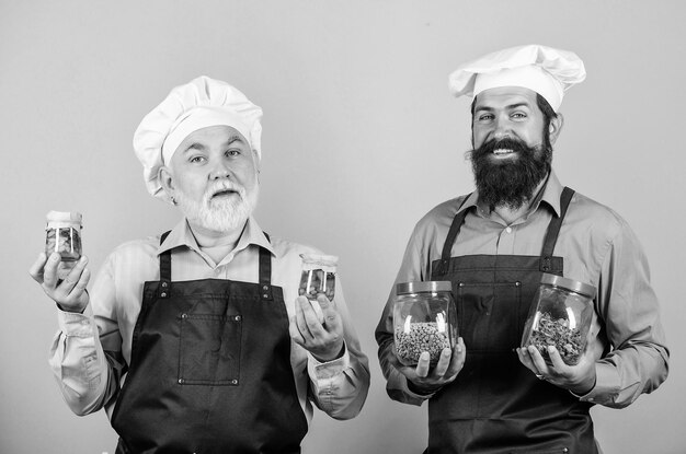 Comenzando el día con comida saludable cocinero profesional hombres mayores barbudos maduros en la cocina Hombres chef cocinando hombres alegres sostienen ingredientes alimentarios preparan comida concepto de cocina alimentación saludable