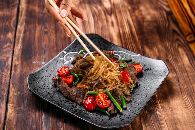 Comer apetitosos fideos de plato asiático funchoza