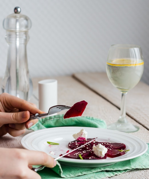 Para comer una ensalada de remolacha asada con queso de cabra, aceite de oliva y sésamo, manos, comida sana