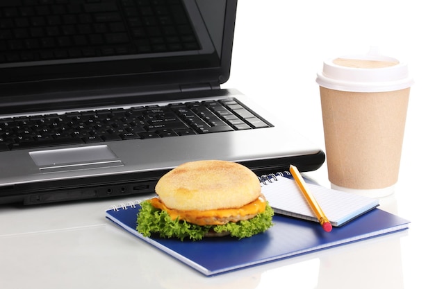 Comer en el lugar de trabajo cerca de la computadora portátil