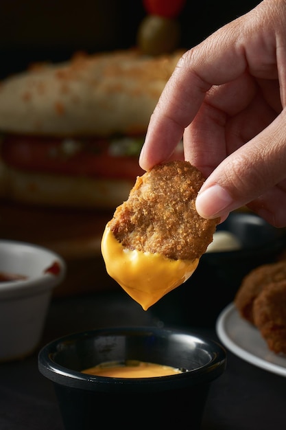 Comer nuggets de pollo con salsa de queso amarillo