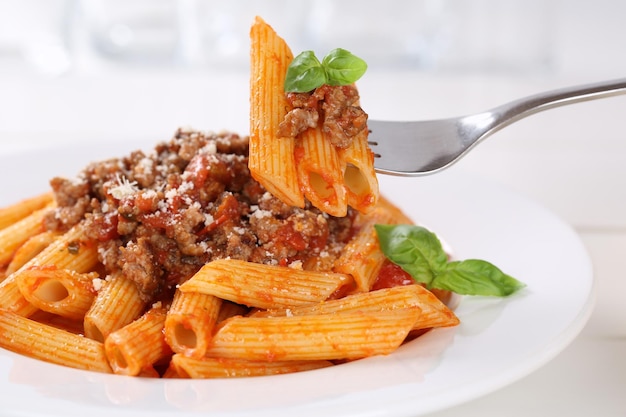 Foto comer pasta de fideos con salsa boloñesa o salsa boloñesa penne rigate