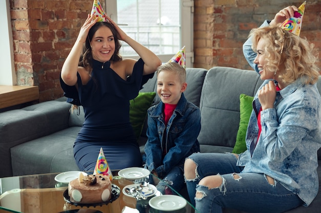 Comer pastel. Madre, hijo y hermana en casa divirtiéndose