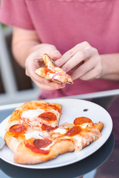 Comer pizza cocinada en una parrilla de gas al aire libre.