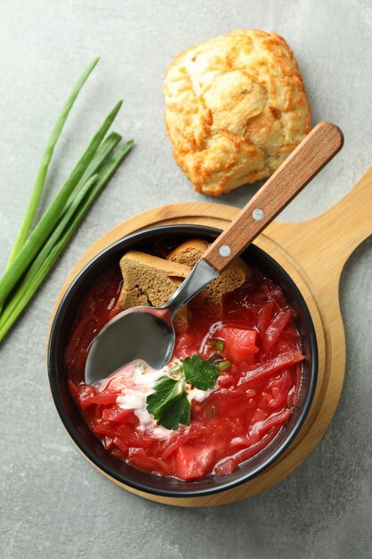 Comer sabroso con borscht en mesa gris