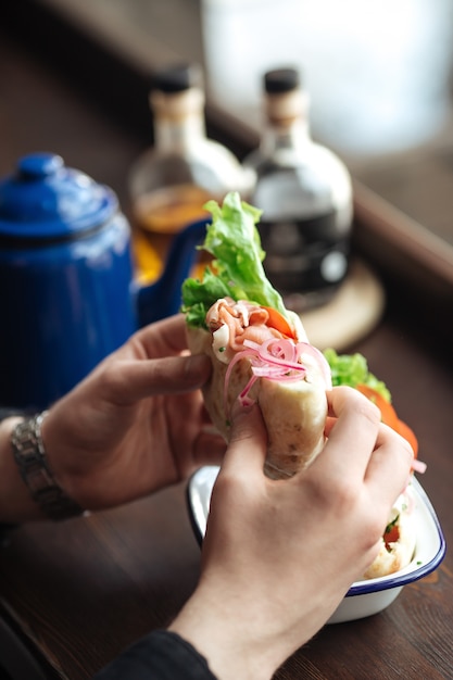 Comer sándwich de pita con verduras y pescado ahumado