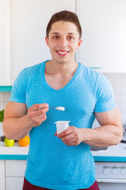 Comer sano joven yogur en la cocina formato retrato desayuno