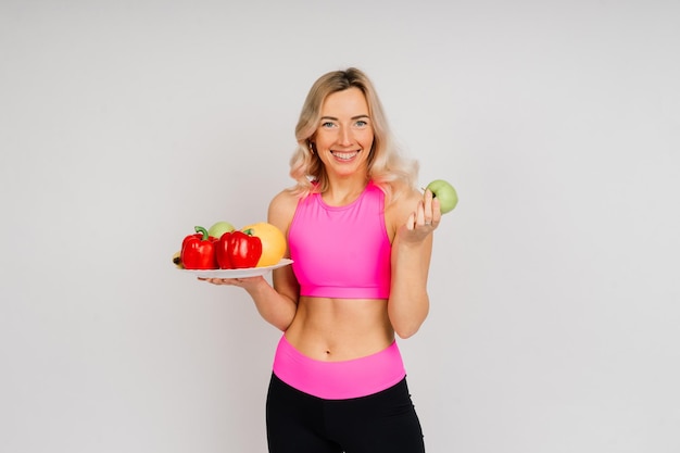 Comer sano, mujer feliz con frutas y verduras está comiendo una manzana