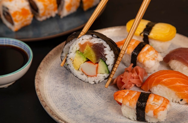 Comer sushi con palillos Etiqueta de sushi de California con cangrejo y verduras japonesas