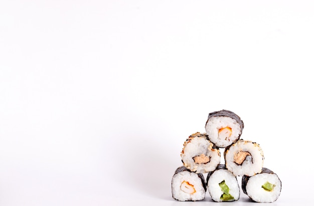 Comer sushi con palillos. Sushi roll comida japonesa en restaurante aislado sobre fondo blanco.