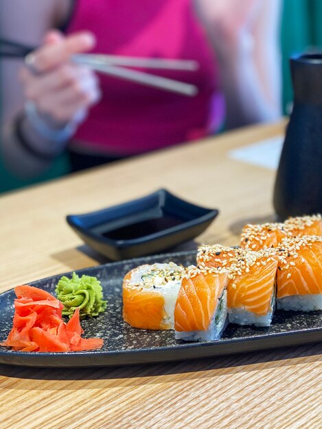 Comer sushi roll en restaurante japonés