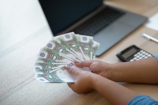 Comerciante de mulher contando dinheiro segurando um monte de home office euro